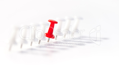 Red push pin in the middle of white push pins