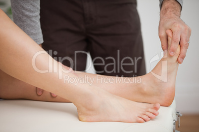 Chiropodist touching the foot of a patient