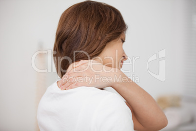 Brown-haired woman massaging her painful neck