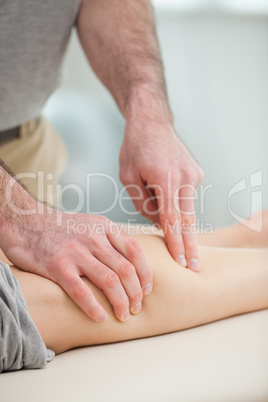 Physiotherapist pressing the calf of a patient