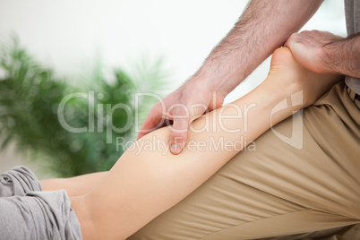 Man massaging the leg of a woman while placing it on his thigh