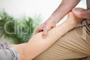 Man massaging the leg of a woman while placing it on his thigh