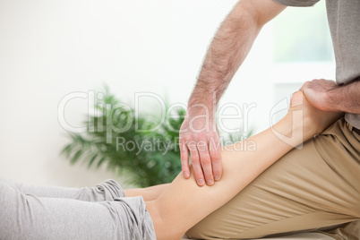Physiotherapist pressing a leg with his fingers