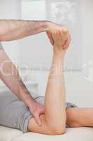 Physiotherapist bending the led of a woman