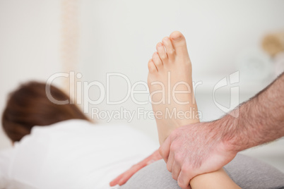 Woman lying forward while a physio manipulates her foot