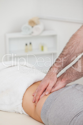 Woman lying while a physiotherapist massing her back