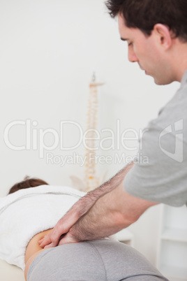 Physiotherapist massaging the lower part of the back of his pati