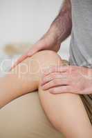 Physiotherapist folding a leg over her thigh