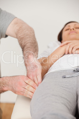 Physiotherapist massaging the thigh of his peaceful patient