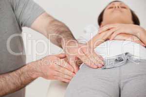 Woman lying while a physiotherapist massaging her thigh