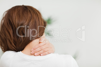 Close up of a brunette woman massing her neck