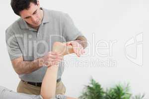 Brown-haired therapist stretching the foot of a patient