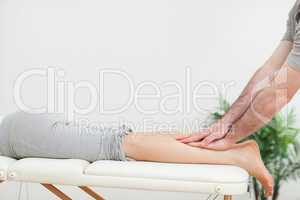 Close up of a masseur massaging the calves of a woman