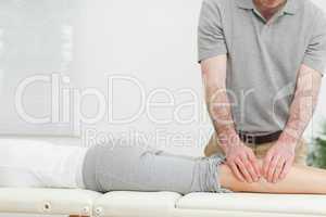 Woman lying while a man is massaging her calves