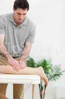 Brunette masseur massaging the leg of a woman