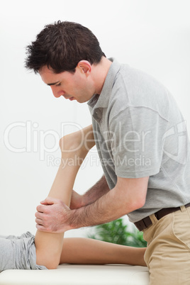 serious masseur massaging the leg of a woman