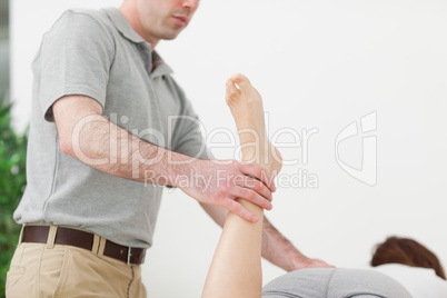 Woman lying while being stretched by a man