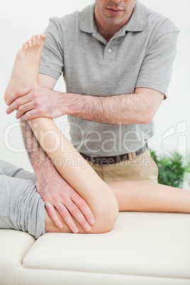 Close-up of a men stretching the leg of a woman
