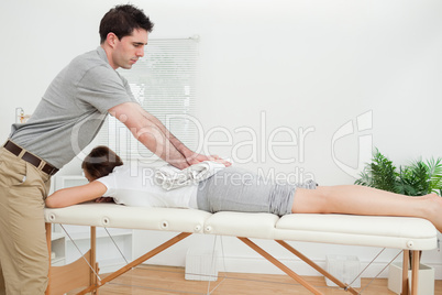 Woman lying while being massaged with a towel