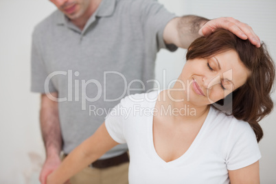 Smiling woman being stretched by a physiotherapist