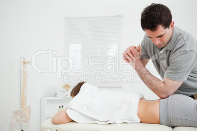 Brunette physiotherapist massaging a woman with his elbow