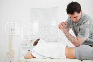 Brunette physiotherapist massaging a woman with his elbow