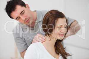Smiling woman sitting while being massaged by a man