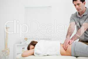 Masseur massaging the back of a brunette woman