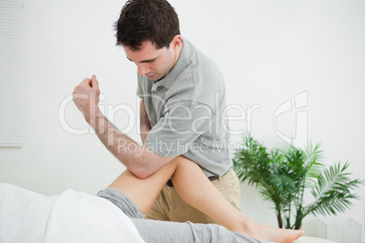 Brown-haired physiotherapist massaging the leg of a woman