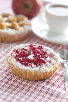 beautiful cake with berries,apple and tea on plaid fabric