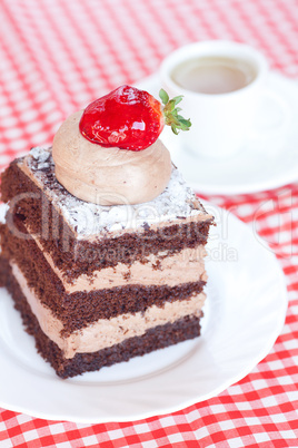 beautiful cake with strawberry and tea on plaid fabric