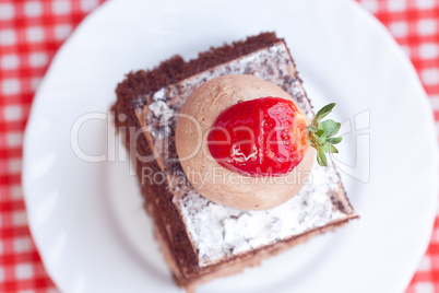 beautiful cake with strawberry on plaid fabric