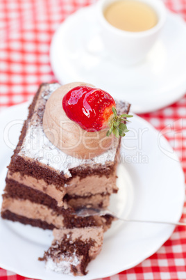 beautiful cake with strawberry and tea on plaid fabric