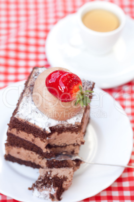 beautiful cake with strawberry and tea on plaid fabric