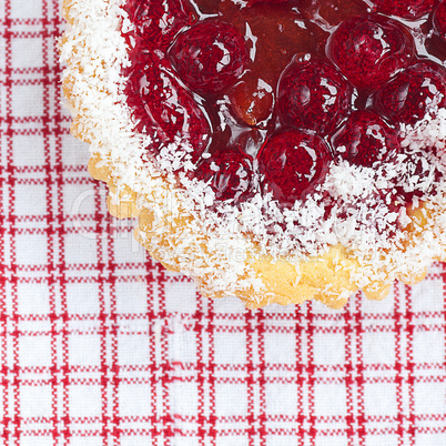 beautiful cake with berries on plaid fabric