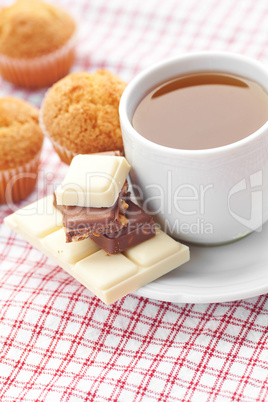 bar of chocolate,tea and muffin on plaid fabric