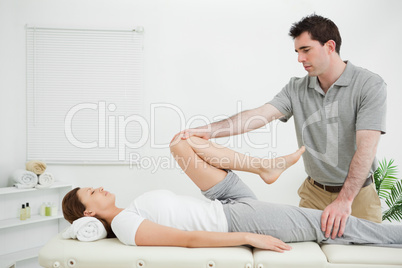 Woman lying on her back while being stretched