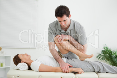 Brown-haired woman being stretched by a man