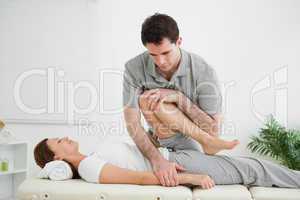 Brown-haired woman being stretched by a man