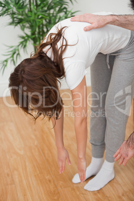 Woman standing while touching her feet with her hands
