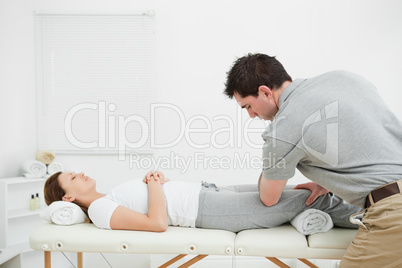 Woman lying on her back while being massaged by a man