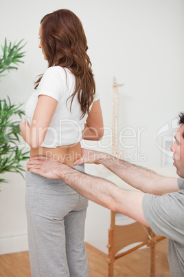 Woman standing while a doctor is touching her back