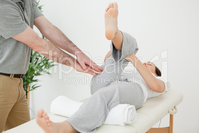 Woman stretching her leg while a man is massaging her