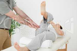 Woman stretching her leg while a man is massaging her