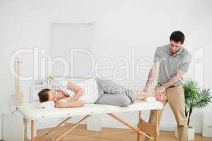 Woman lying on her side while being massaged by a man