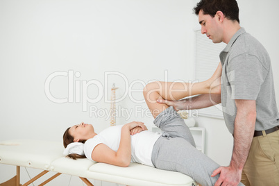 Osteopath stretching the leg of his patient