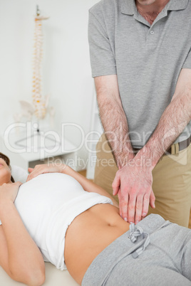 Doctor examining the painful abdomen of a woman