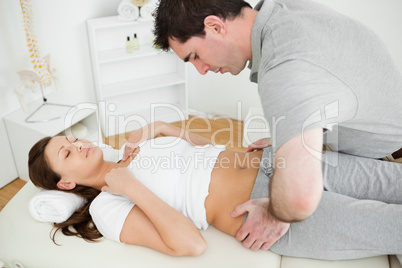 Osteopath placing his hands on the hips of a woman