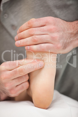 Two fingers pressing the sole of a foot