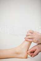 Chiropodist using his index finger to massage a foot